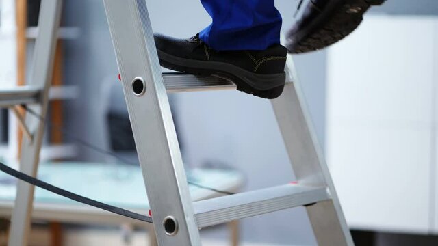 Man In Shoes Climbing Step Ladder. Safety