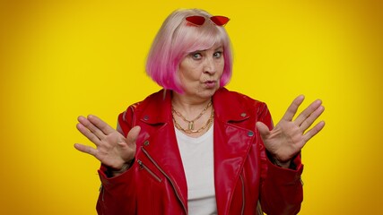 I am not guilty. Confused senior old granny woman with pink hair pointing fingers himself ask say...