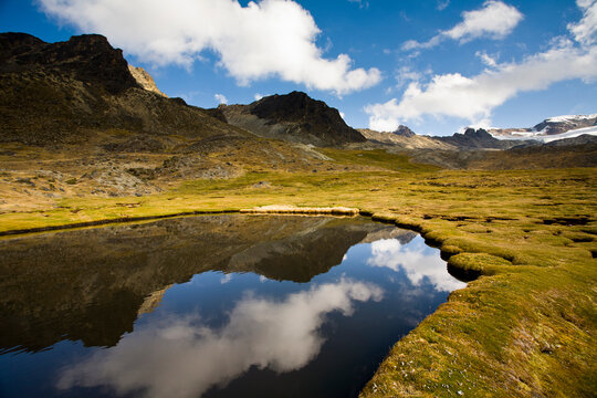 A high-altitude bog lies near Mt. Cuchillo (18,553'/5,655m) and reflects the surrounding peaks of the Apolobamba Range in Bolivia. during winter.