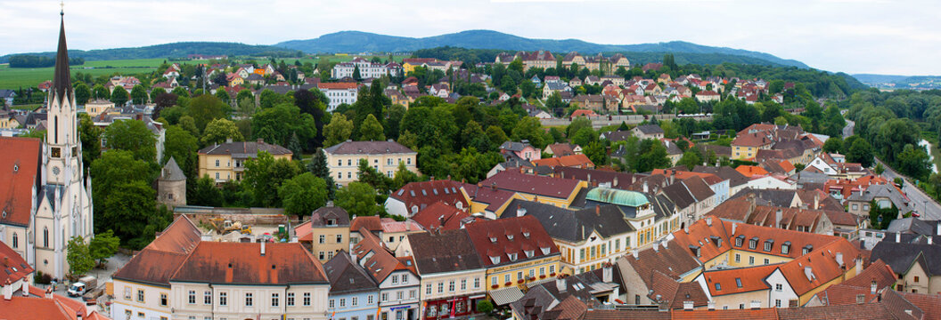 Melk, Austria: Panorama from above quaint village with many colorful buildings, mountains in the background
