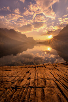 The sun sets on a calm evening over St. Mary's Lake in Glacier Park.