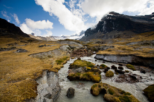 A high-altitude bog lies at the foot of Mt. Cuchillo (18,553'/5,655m) and reflects the surrounding peaks of the Apolobamba Range in Bolivia during winter.