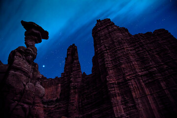 Fisher Towers at night - The classic 5.11 tower climb can be seen silhouetted against the night sky - Moab, Utah