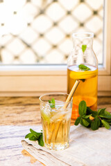 The glass of citrus iced tea on a marble tray and wooden table.
