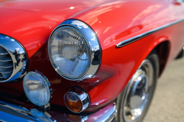 Obraz na płótnie Canvas Detail of chrome and headlamps of classic red colour vintage car