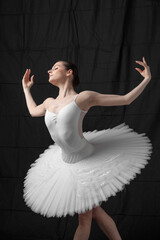 Naklejka premium Young beautiful skinny ballerina is posing in studio