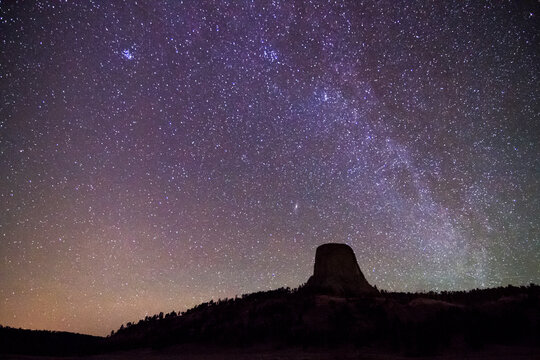 The Milky Way Galaxy stretches above Devil's Tower in Devil's Tower National Monument, Wyoming.