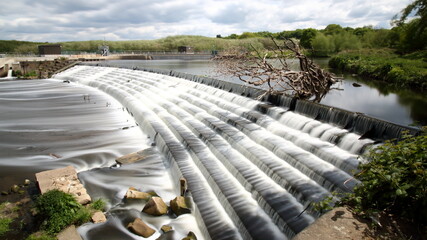 Long 30 second exposure of a weir on the river Calder in Wakefield England - obrazy, fototapety, plakaty