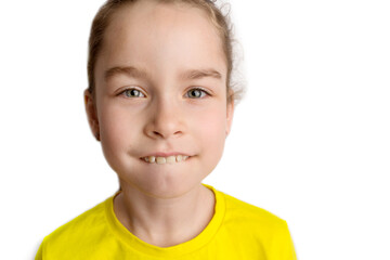 Little girl stands on a white background with a beautiful smile, children crooked teeth, pediatric...