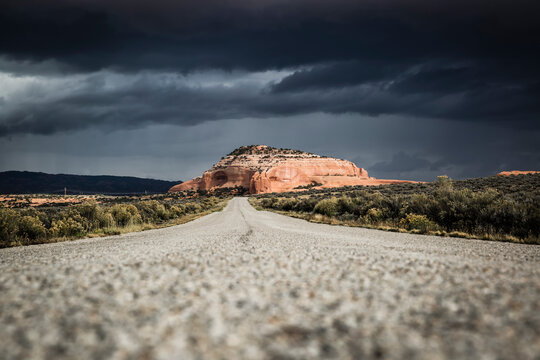 Rock formations in Monticello, Utah painted with light during an on coming desert storm as seen from a country road