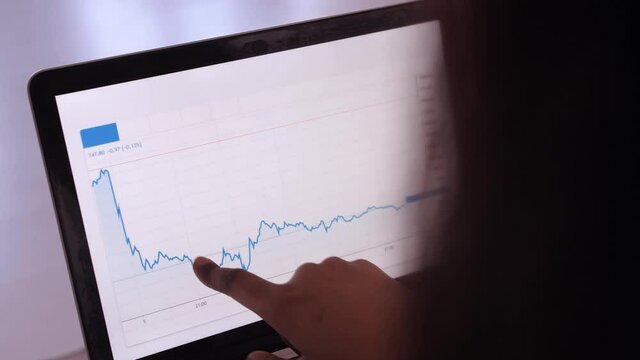 african american woman doing stock exchange chart analytics on laptop