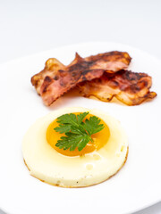 fried eggs with bacon on white plate