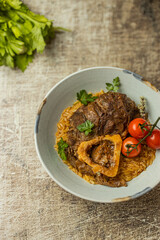 Osso buco traditional italian meat dish served with herbs and tomatoes