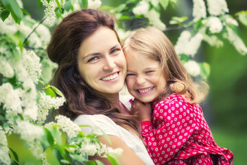 Portrait of happy mother and little daughter in spring park