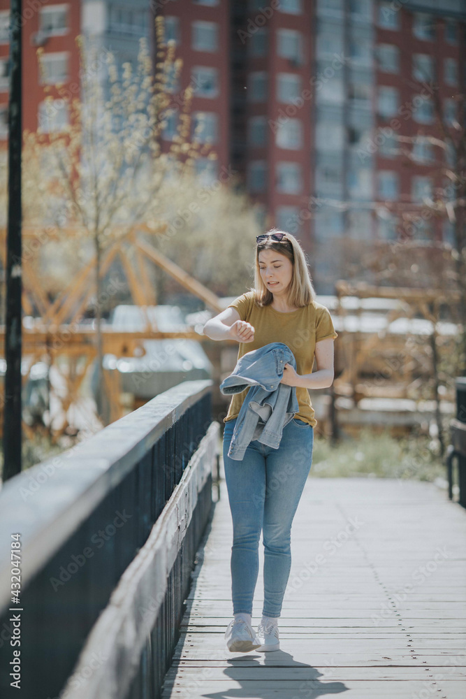 Sticker young caucasian female checking the time and realizing she is late while walking on the street