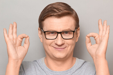 Portrait of happy cheerful optimistic man showing okay gestures