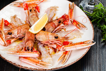 Seafood. Langoustine, scampi or Norway lobster with lemon on white plate.