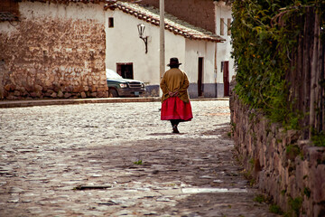 bella Mujer de los andes camina por una calle de un hermoso pueblo de piedras