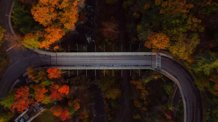 Aerial of Stewart Avenue Deck Truss Bridge over Canyon & Waterfall - Peak Autumn Colors - Ithaca, New York - 432050383