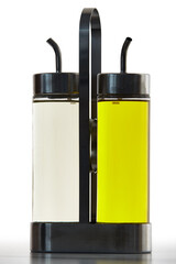 Bottles with a cap nozzle, for oil and vinegar, placed in a metal holder rack.