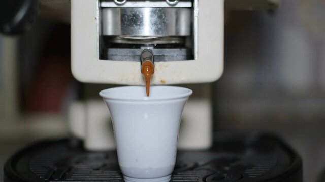 Coffee capsule pods machine making espresso in a plastic cup for morning breakfast,caffeine hot drink