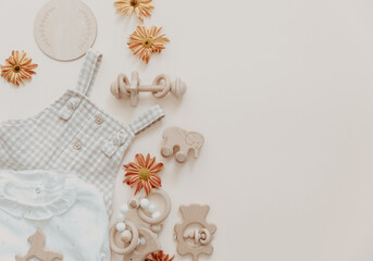 Light soft baby pants with wooden toys and flowers. Fashion newborn, bohemian style, neutral beige...