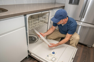 Appliance repairman working on a broken dishwasher