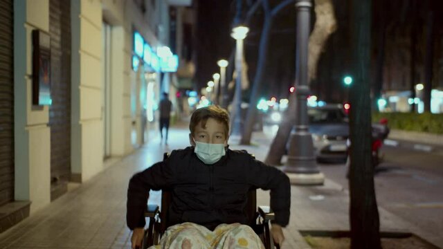 Handicapped child in wheelchair outside in the evening