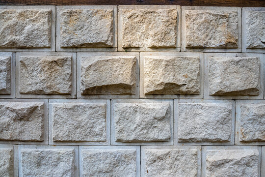 Wall lined with decorative stone. The rough surface of the stones. Beautiful masonry in a classic style. Vintage texture great for background and design.