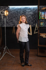 a girl in strict clothes stands at a school blackboard with inscriptions