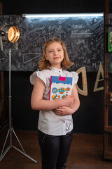 a girl in strict clothes stands at a school blackboard with inscriptions