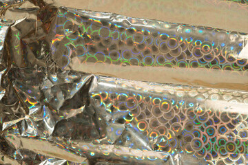 gold metallic wrapping paper with iridescent or spectral shine (circles) with folds and creases