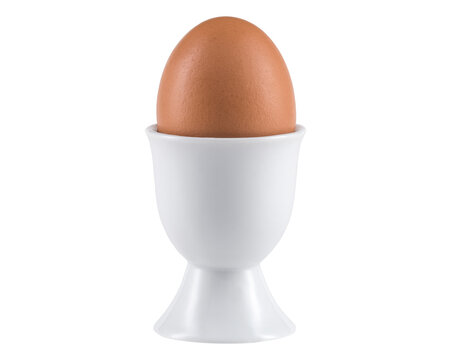 Egg in Egg cup. Ceramic eggcup for breakfast. Holder stand for boiled or raw chicken eggs on white isolated background. Macro close-up photography.