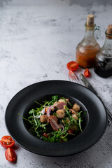 Bacon and rocket spicy salad with roasted croutons on a stone table in a restaurant