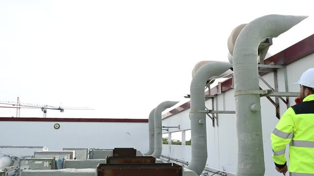 Air conditioning technicians repair and maintain condensing units outside the building, engineers inspect the operation of ventilation fans.