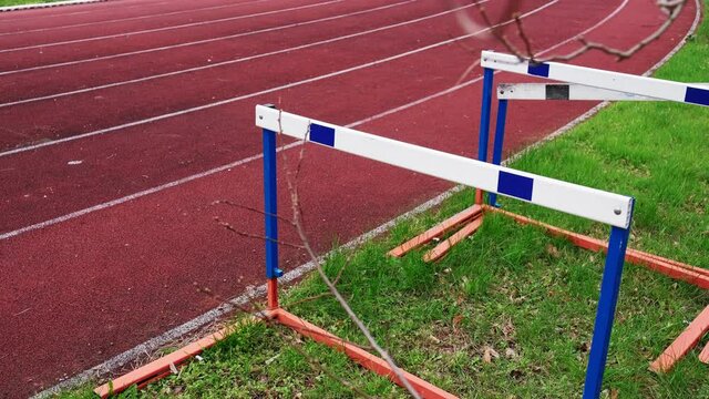 Hurdling Obstacles Standing Next to Running Track at Athletics Stadium