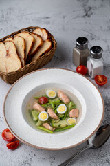 Zero calorie, diet soup with salmon, eggs and broccoli, protein soup top view on a stone table
