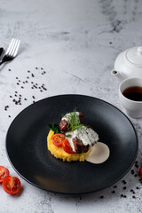 Filet mignon with mashed potato on black plate in a restaurant