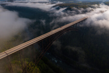 Aerial of New River Gorge Bridge on Foggy Spring Morning - US Route 19 / Corridor L - New River Gorge National Park & Preserve - West Virginia
