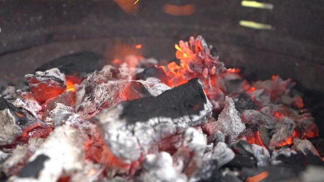 Ascuas y carbon encendidos ardiendo en barbacoa metalica
