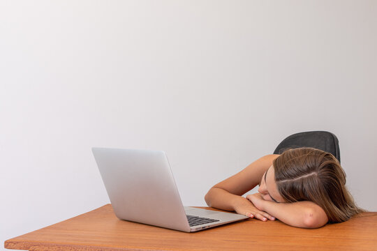 Crian&ccedil;a em frente ao computador cansada e deitada 