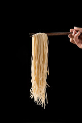 noodles at chopsticks isolated on black background.