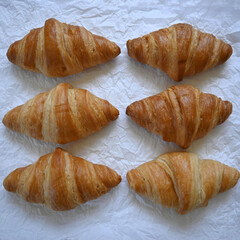 Close-up delicious traditional golden croissants on paper background