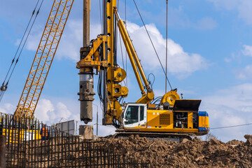 Yellow hydraulic drilling rig on a high-rise building construction site. Installing a bored piles with a casing string. Foundation skyscraper © hodim