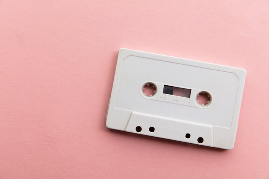 vintage white cassette tape on a pastel pink background