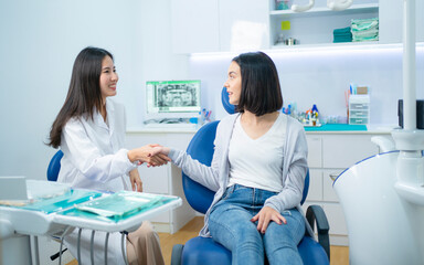 Caucasian girl patient greeting dentist by making handshake in clinic.