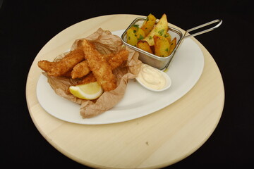 fish with flakes and French fries with mayonnaise and lemon