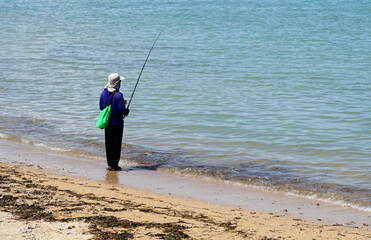 person fishing on a beach