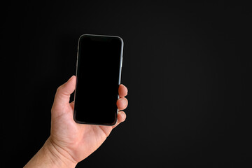 Man holding mobile phone, close-up of hand