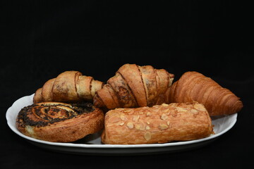 plate with croissants and strudel with almonds